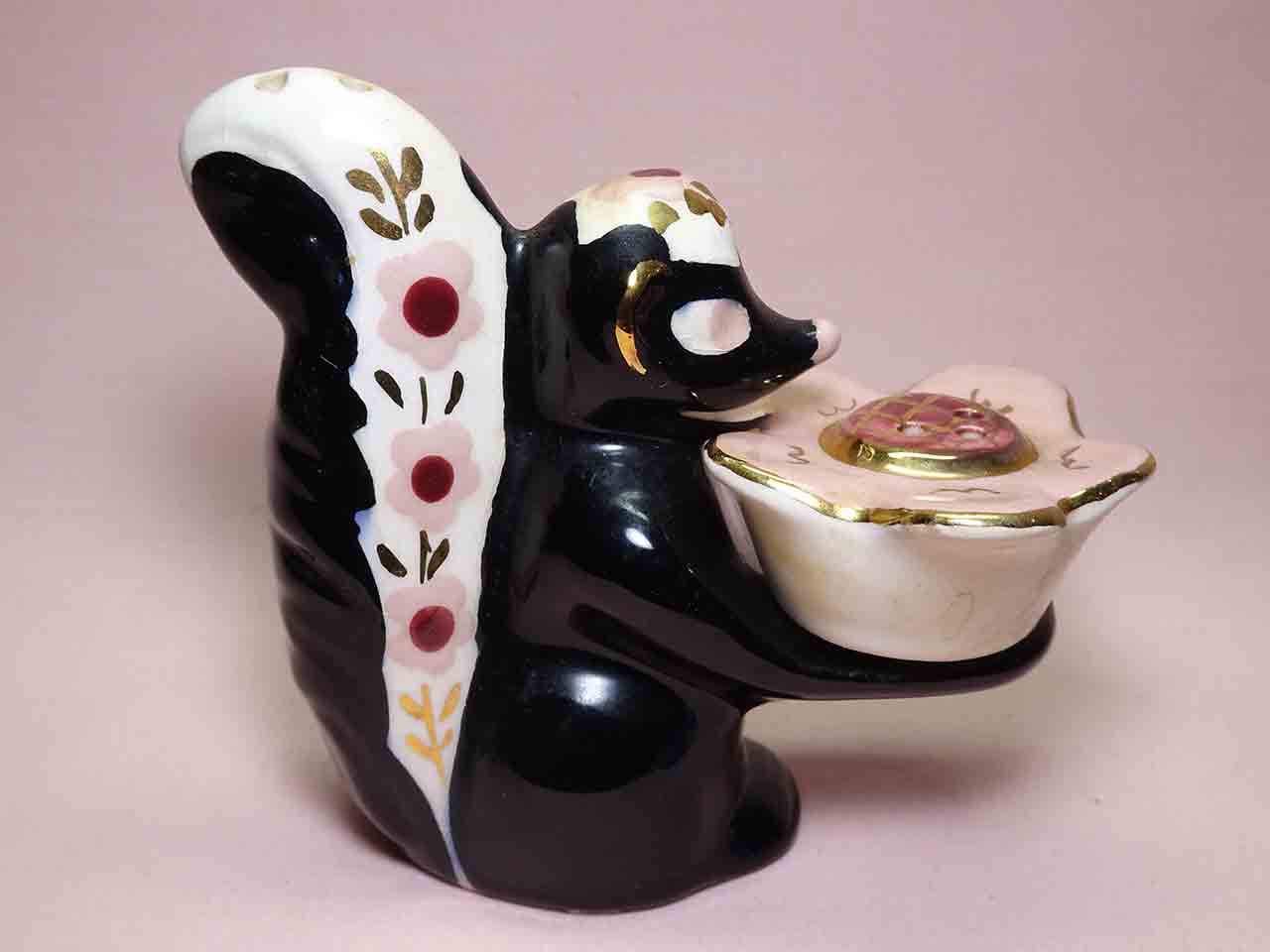 42329 Poinsettia Studios California salt and pepper shakers - skunk holding flower